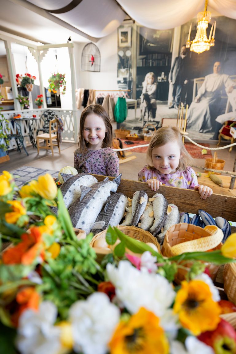 Kaksi tyttöä Leikkilän torikaupan pöydän ääressä.