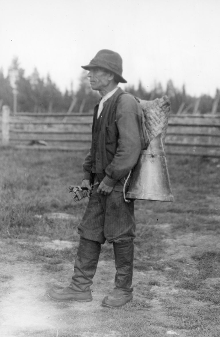 Mies, jolla selässään reppu ja mittauskannu.