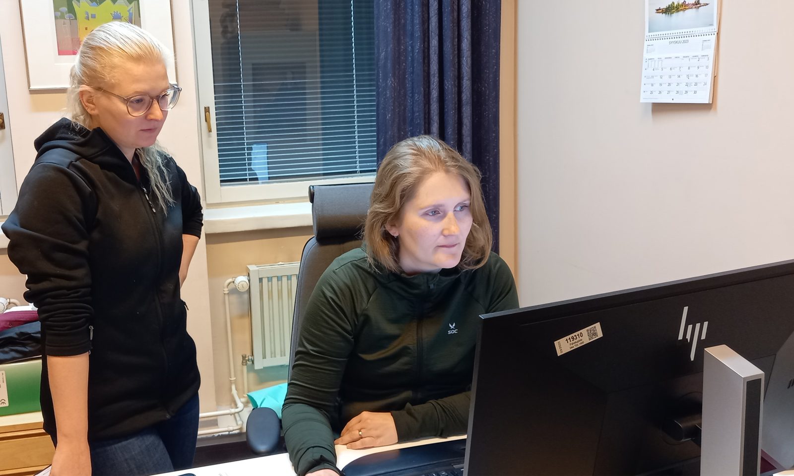 kaksi henkilö katsomassa tietokoneen ruutua.