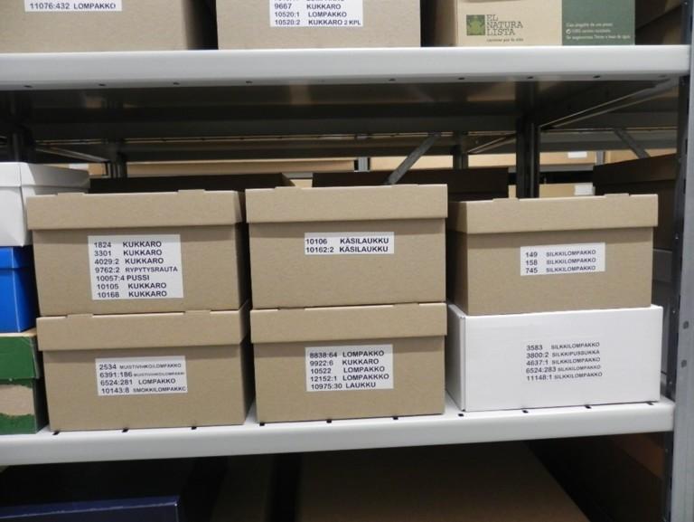 Laatikoita päällekkäin hyllyllä.