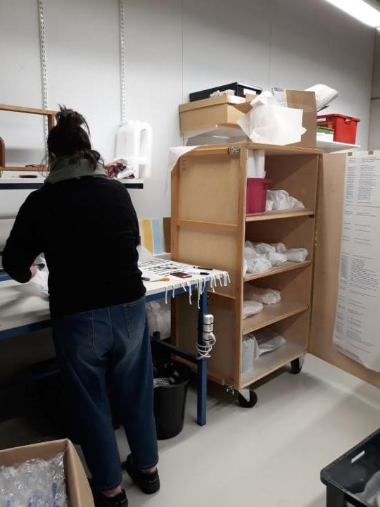 Konservaattori pakkaamassa esineitä.