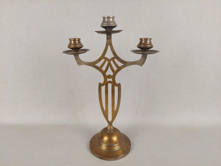 Kuparin värinen kynttilänjalka, jossa paikka kolmelle kynttilälle.