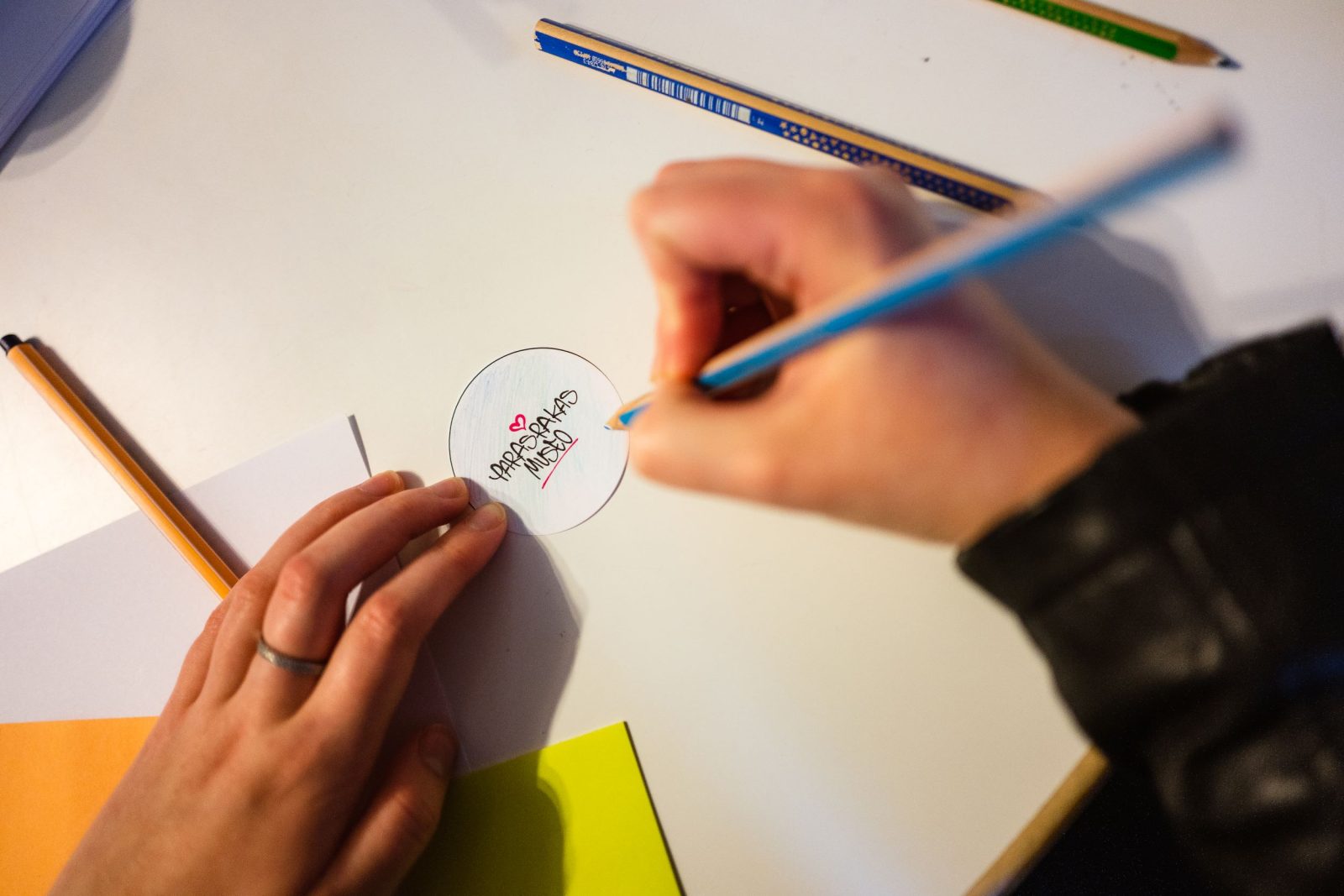 Kädet värittämässä Paras Rakas museon logoa.