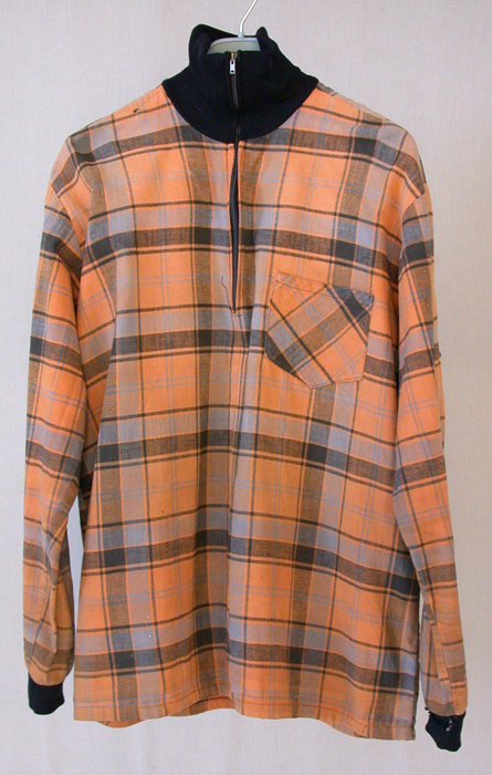 Ruutupaita, pääosin oranssi, hieman valkoista ja harmaata seassa.