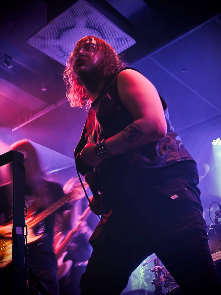 Bändi lavalla esiintymässä, laulaja etualalla