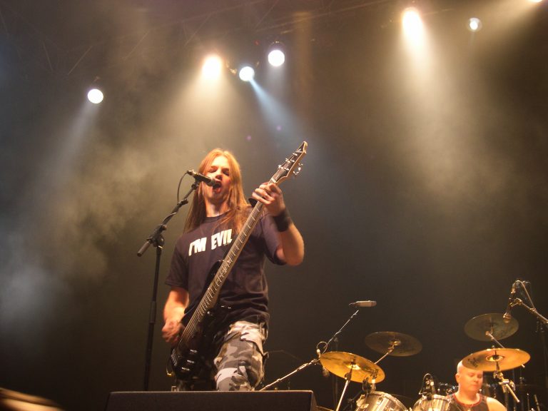 Keikkalavalla valonheitinten alla etualalla vokalisti-basisti Altti Veteläinen. Taustalla rummut ja rumpali.