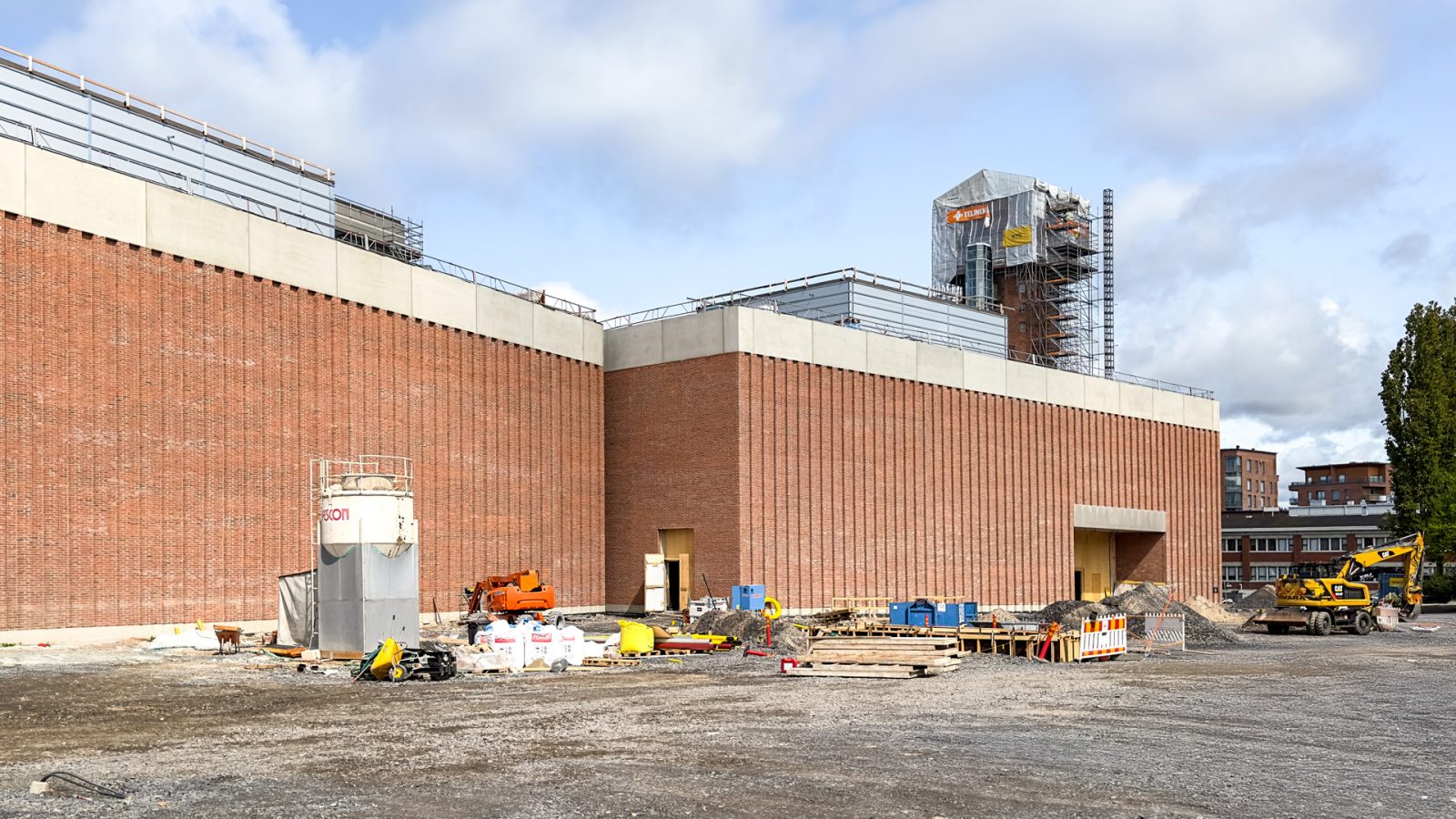 Rakennustyömaa iso punatiiinen rakennus.