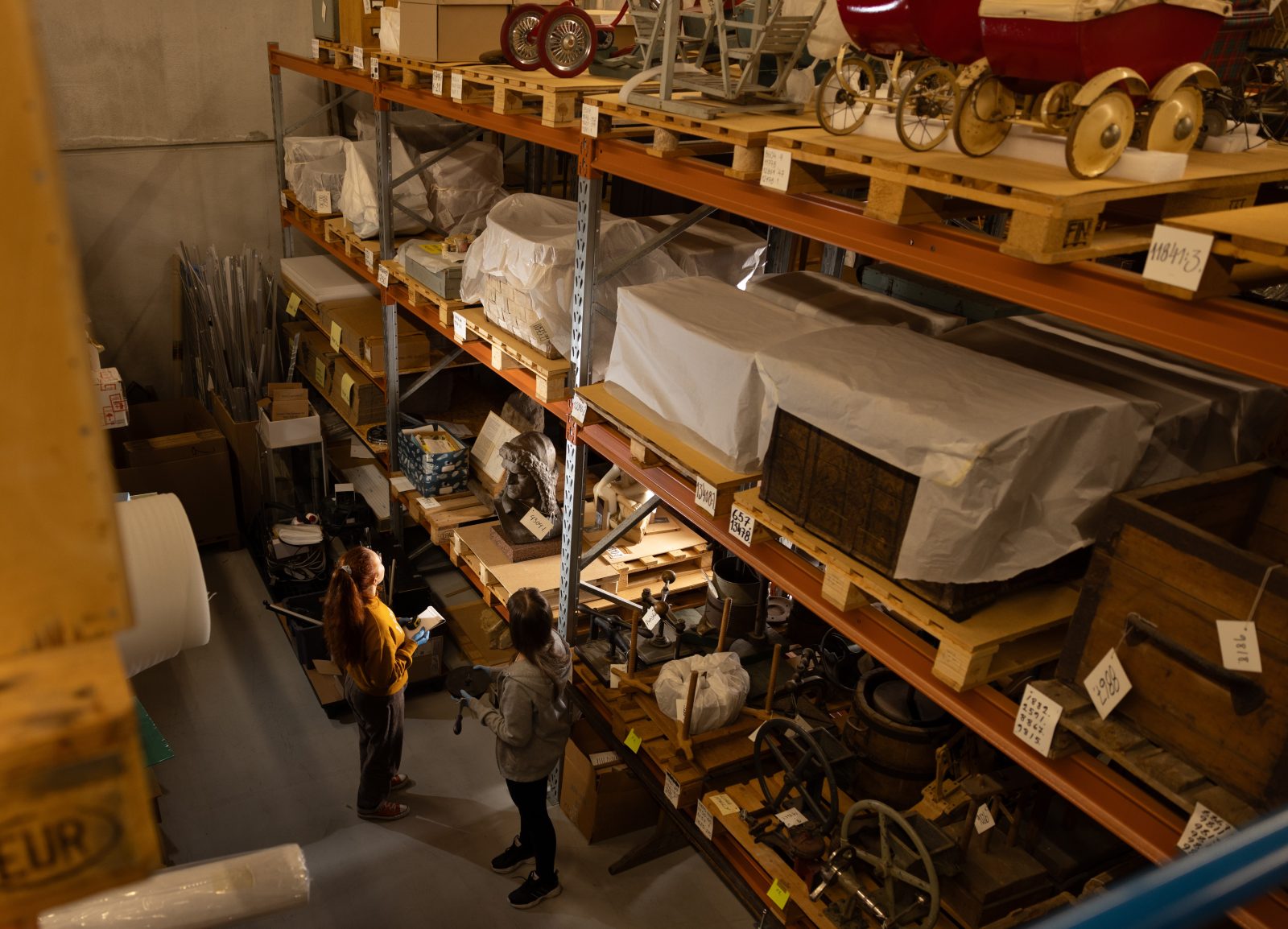 Paljon puisia museoesineitä varaston hyllyllyillä.