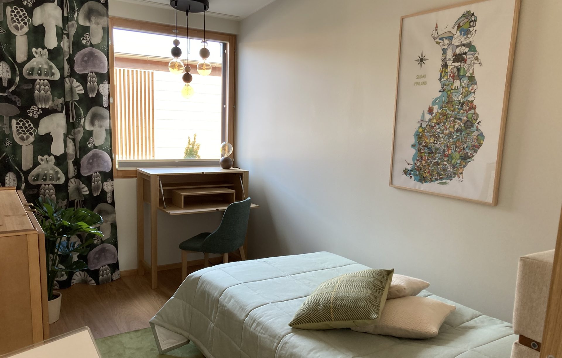 Makuuhuone, jossa sisustus vaaleaa puuta ja tekstiilit vaalean vihreää sävyä.