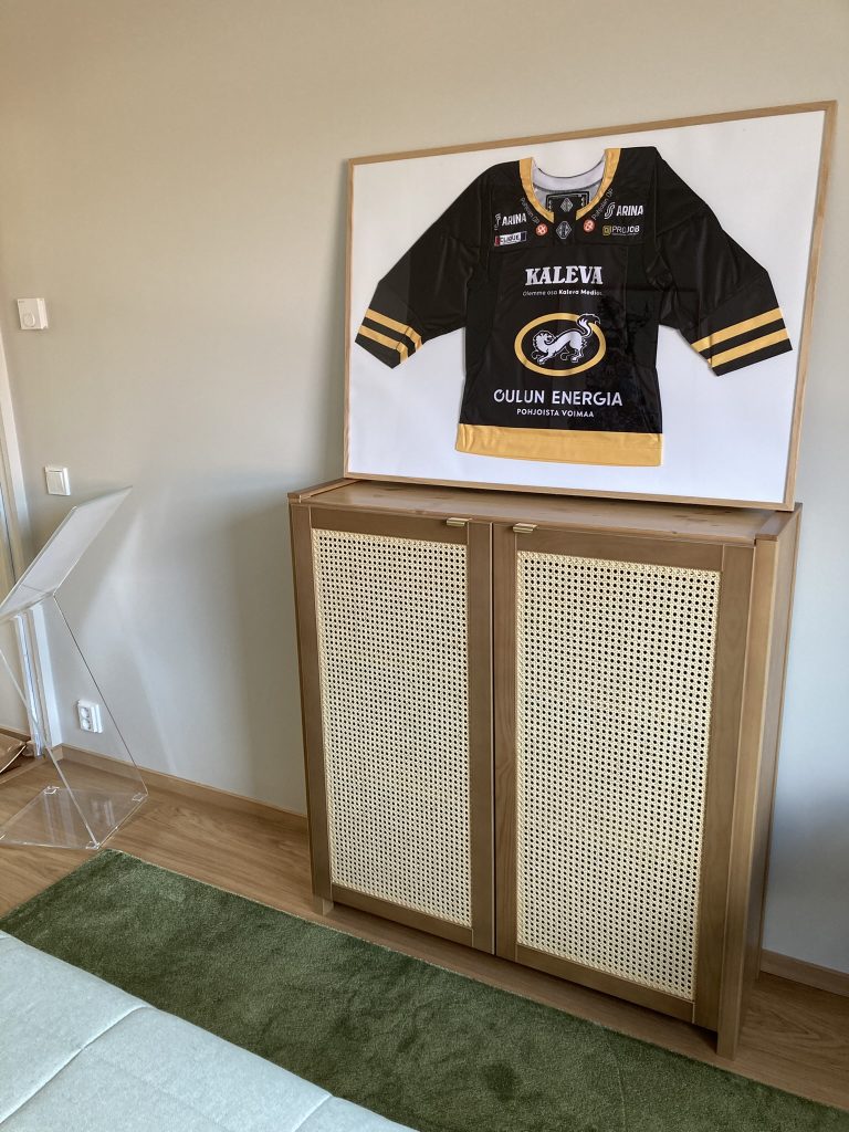 Kärppäpaita kehyksissä senkin päällä.