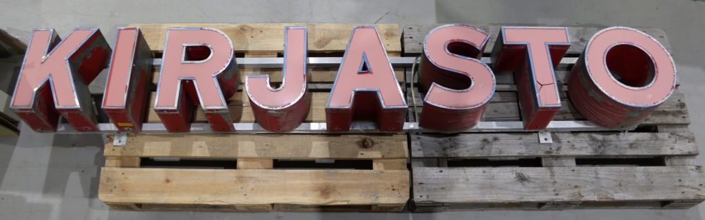 Punaisia valokirjaimia puulavalla. Kirjaimista muodostuu sana kirjasto.