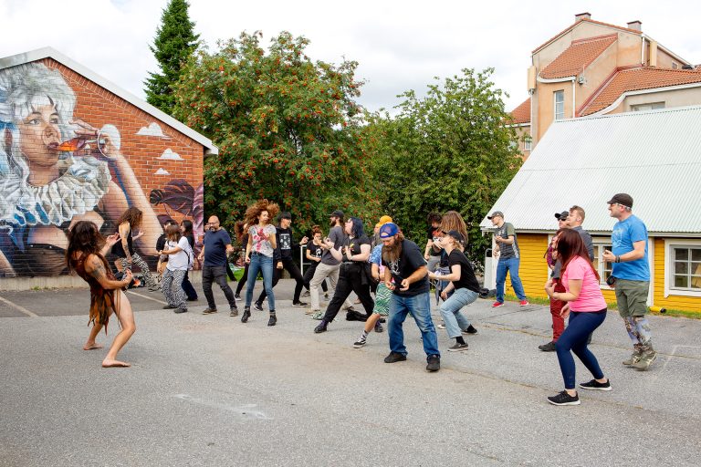 Joukko ihmisiä soittaa näkymättömiä kitaroita.