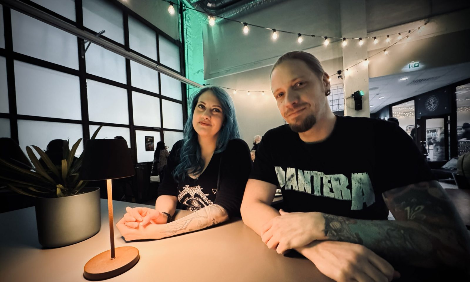 Kaksi henkilöä pöydän ääressä hämyisässä baariympäristössä.