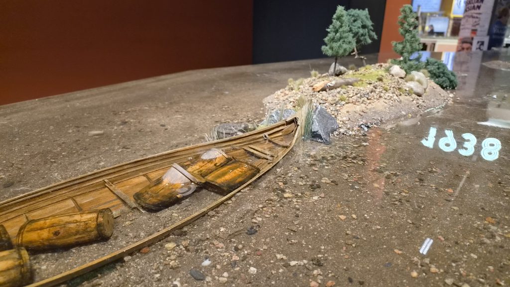 Tervatynnyreillä täytetty vene ja hiekkainen saari valettuna epoksiin.